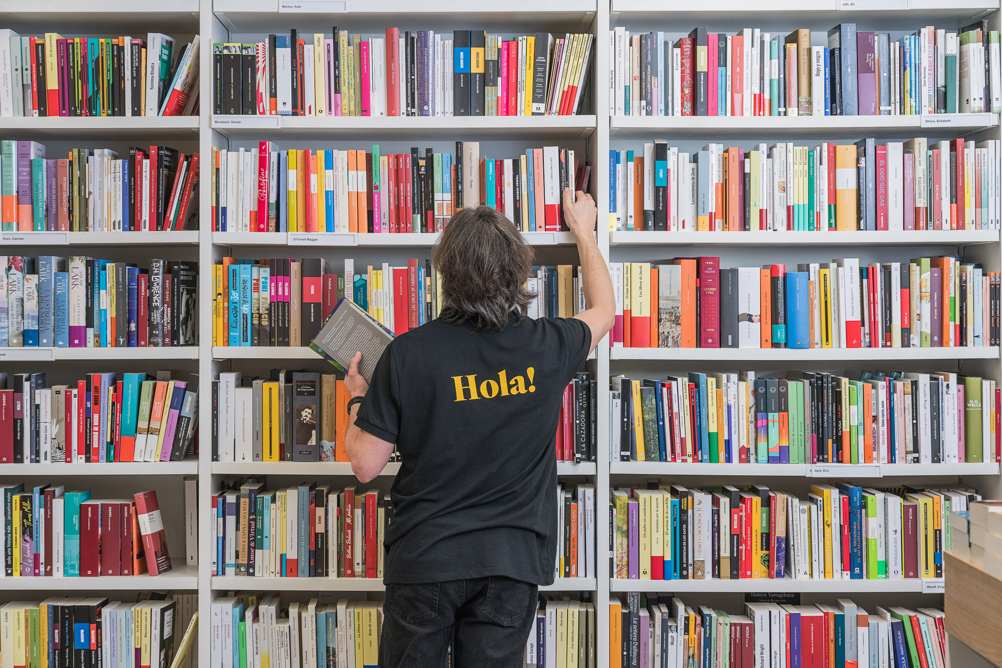 En la imagen se puede ver a un trabajador de Abacus escogiendo libros de una estantería.